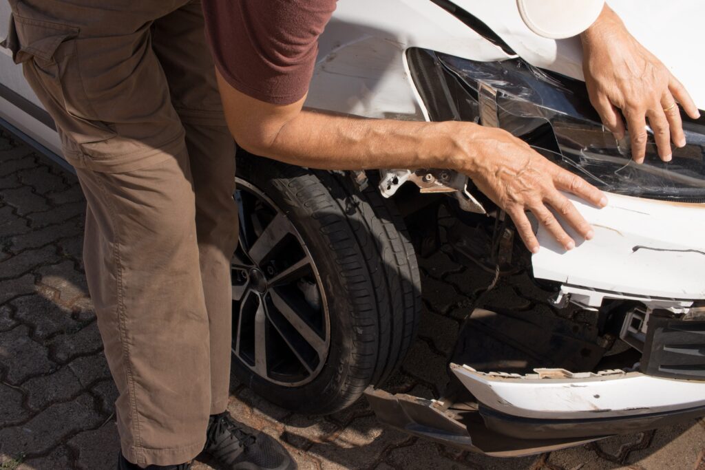 Man,Checking,Out,The,Damage,To,The,Right,Front,End