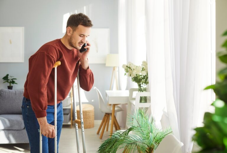 injured man posing on crutches after